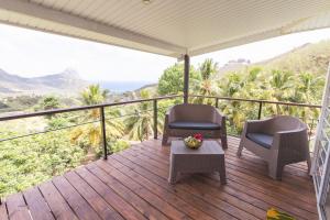 a deck with two chairs and a table with a view at Ataku'a Lodge in Hakamui