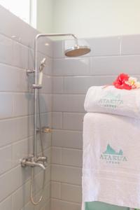 a shower with towels on a towel rack in a bathroom at Ataku'a Lodge in Hakamui +4 photos