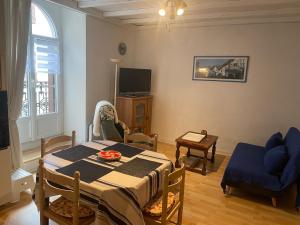 a living room with a table and a blue chair at La Cascade appartement F2 in Eaux-Bonnes