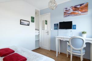 a bedroom with a bed and a desk and a tv at Bla Hus B&B in Reykjavík