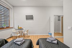 two beds in a room with a table and a tv at Central Platinum Apartments 4 in Rybnik