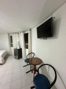 a living room with a table and chairs and a tv at Rosarito By The Sea in Rosarito