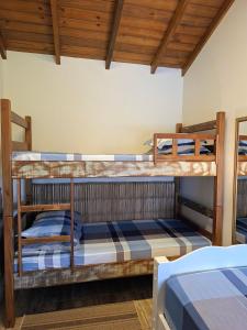 two bunk beds in a room with wooden ceilings at Casa das Dunas in Garopaba