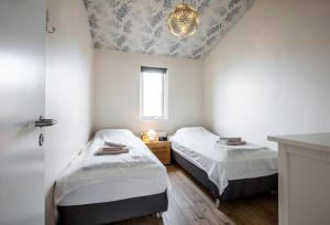a bedroom with two beds and a ceiling with a chandelier at Bla Hus B&B in Reykjavík