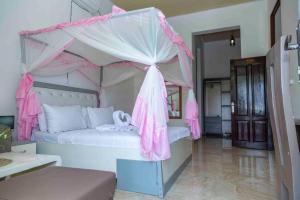 a pink bed with a canopy in a room at The city Block Apartment in Bujumbura +173 photos