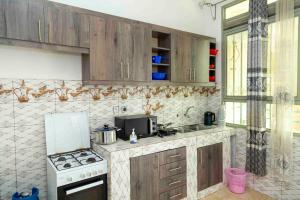 a kitchen with wooden cabinets and a stove top oven at The city Block Apartment in Bujumbura