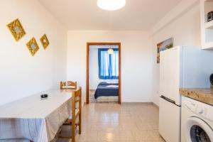 a kitchen with a refrigerator and a bed in a room at Barbarossa Apartments in Vrachonisída Prasonísi