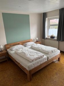 a large bed in a bedroom with a window at Haus Seeburg in Carolinensiel