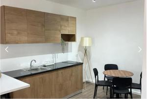 a kitchen with a sink and a table with chairs at Milo's Villa in Dhërmi
