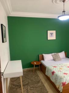 a bedroom with a bed and a green wall at Dalal Diam in Dakar