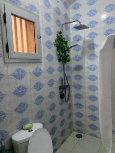 a bathroom with a toilet and a window and a shower at Dalal Diam in Dakar +7 photos