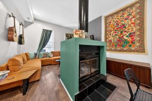 a living room with a green fireplace and a couch at Stylish STL Gem ABODEbucks in Saint Louis