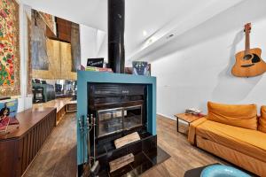 a living room with a fireplace and a guitar at Stylish STL Gem ABODEbucks in Saint Louis +23 photos
