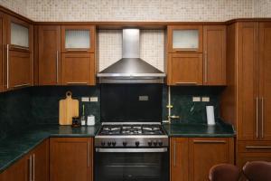 a kitchen with wooden cabinets and a stove top oven at The New Cairo 3BR Residence in Cairo