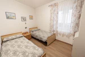 a bedroom with two beds and a window at La bottega del sarto in Grumes