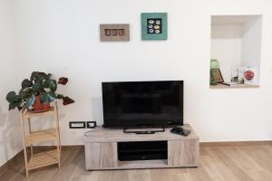 a living room with a flat screen tv on a table at La bottega del sarto in Grumes +10 photos
