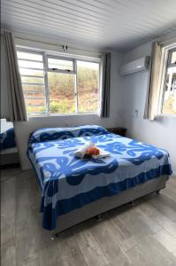 a bedroom with a bed with a blue and white comforter at Ataku'a Lodge in Hakamui