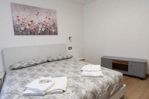 a bedroom with a bed with two towels on it at La bottega del sarto in Grumes
