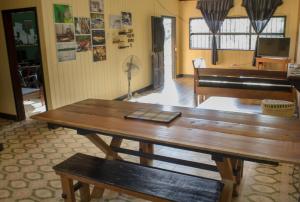 Habitación con mesa de madera y piano en Hostel Casa de las Palmas Tours, en Leticia
