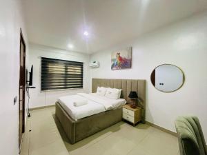 a bedroom with a bed and a mirror in it at Blue Bell Suites in Lekki