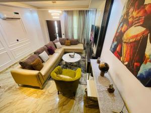 a living room with a couch and a table at Blue Bell Suites in Lekki +30 photos