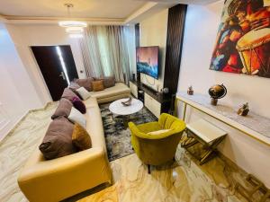 a living room with a yellow couch and a yellow chair at Blue Bell Suites in Lekki