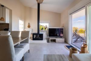 a living room with a fireplace and a tv at Villa Keyd Mare in Porto Rafti