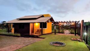 a small house with a patio and a yard at Casa das Dunas in Garopaba