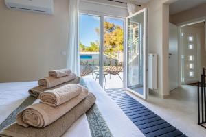 a bedroom with a bed with towels on it at Villa Keyd Mare in Porto Rafti +101 photos