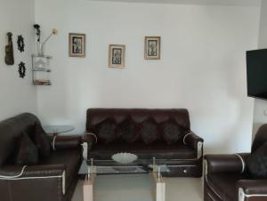 a living room with a leather couch and a table at Dar Yasmine 2 in Ifrane