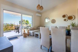 a living room with a couch and a table with chairs at Villa Keyd Mare in Porto Rafti