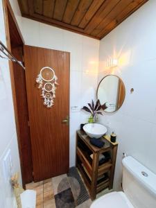a bathroom with a wooden door and a sink at Casa das Dunas in Garopaba +54 photos