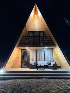 a house with a pointed roof with couches at WoodCottage in Borjomi