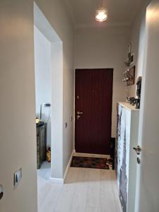 a hallway with a brown door and a white tile floor at Cosy studio in Bucharest +3 photos