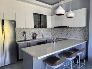 a kitchen with a large island with bar stools at Ranbin Retreat in Manadhoo