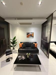 a living room with a couch and a table at Modus Pattaya Beachfront Apartment in North Pattaya