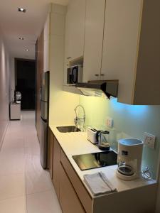 a kitchen with a sink and a microwave at Modus Pattaya Beachfront Apartment in North Pattaya +25 photos