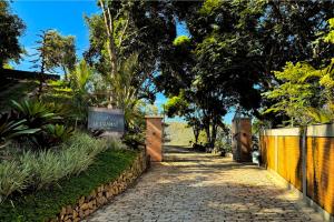a path in a garden with a fence and trees at Siramat Hotel in Petrópolis +46 photos