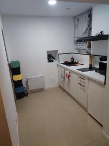 a small kitchen with white cabinets and a tile floor at Le Cocoon Léréen in Léré