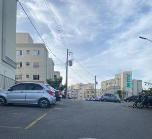 a parking lot with cars parked in front of buildings at Ap Hostel For You in Serra
