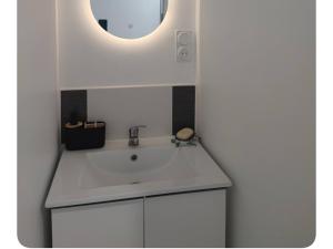 a bathroom with a white sink and a mirror at Le Cocoon Léréen in Léré