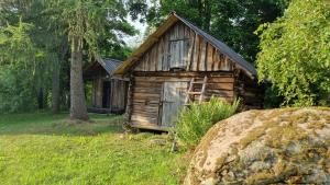 a small wooden cabin in the middle of a field at Oandu Camping saunamaja in Oandu
