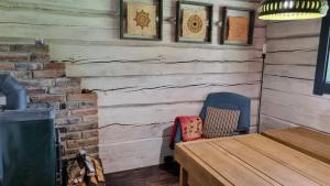 a dining room with a wooden table and a chair at Oandu Camping saunamaja in Oandu