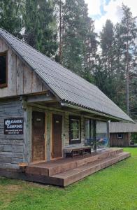 a small wooden building with a bench in front of it at Oandu Camping saunamaja in Oandu