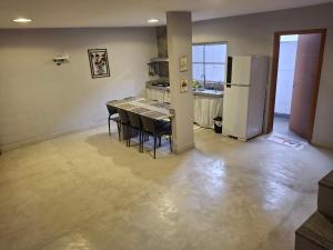 a kitchen with a dining table and a refrigerator at Casa na praia prática aconchegante in Serra
