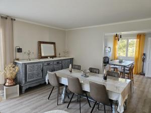 a dining room with a table and chairs and a mirror at L'Oustal in Saint-Constant