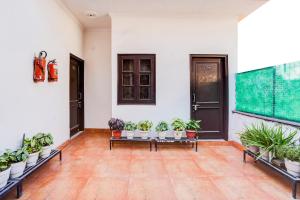 a room with a bunch of potted plants on benches at Super Hotel O Tyagi Road Near Prince Chowk Formerly Hotel Prabhu in Dehradun