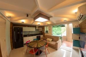 a kitchen and a living room with a table and chairs at Bombinhas Summer Beach - Cond Apart Privados in Bombinhas