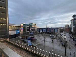 a city with a parking lot with cars and buildings at Comfy 2bed flat next to Motorpoint Arena in Nottingham