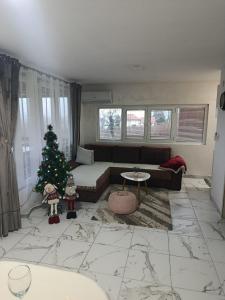 a living room with a christmas tree and a couch at Vikendica Bambi - Vrdnik in Vrdnik +22 photos